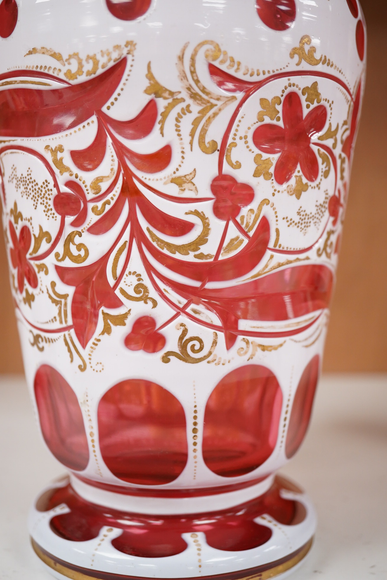 A 19th century Bohemian overlaid and gilt decorated cranberry glass vase, 29cm high. Condition - gilt decoration worn in places